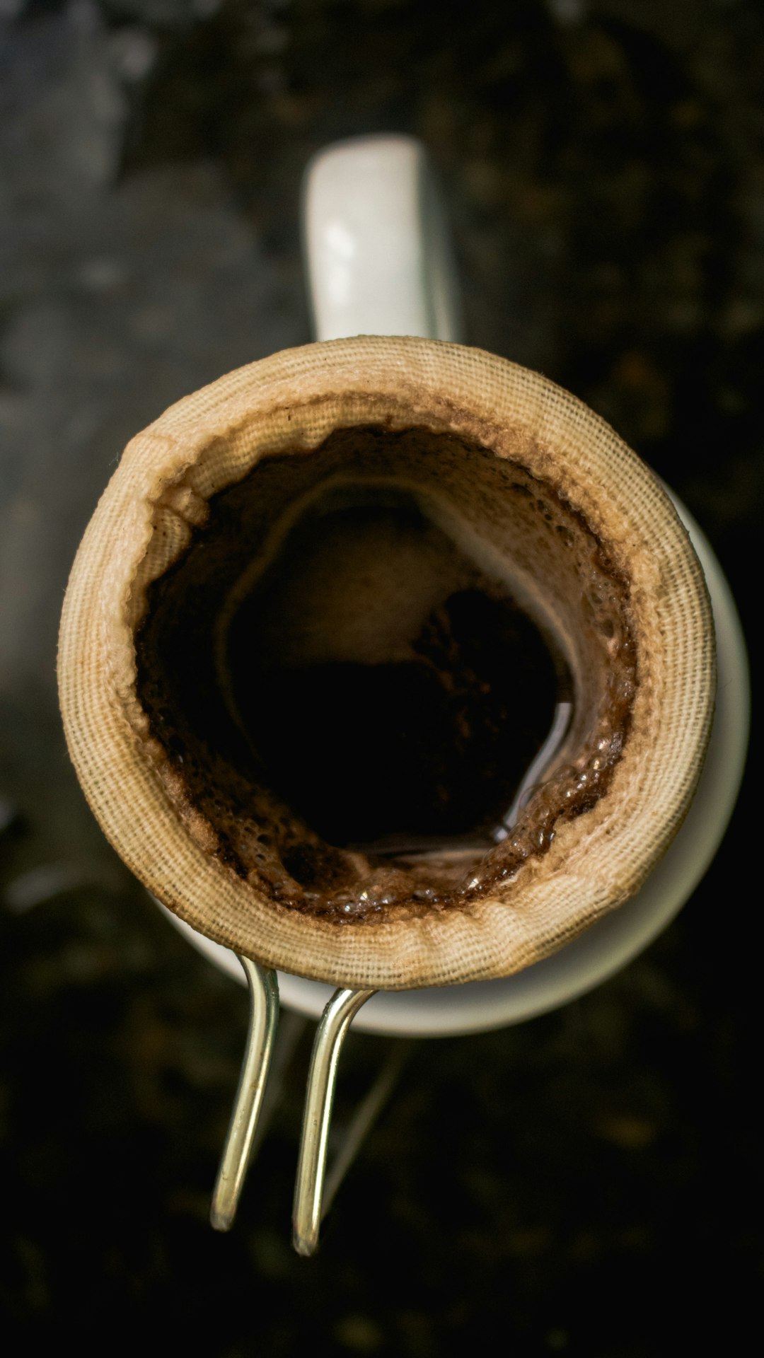 Close-up of a hot coffee being poured into an insulated mug